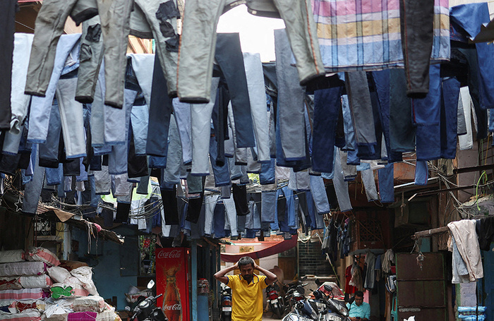 Просушка новых джинсов перед продажей на оптовом рынке в Калькутте. Индия.