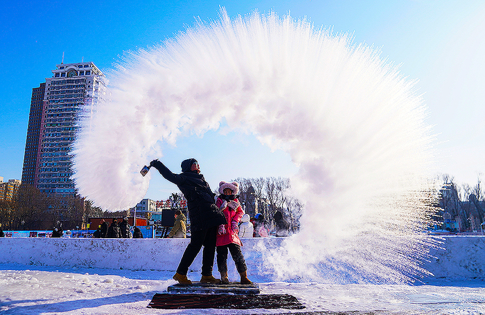 Разбрызгивание воды для превращения в лед в морозную погоду в китайском Харбине.