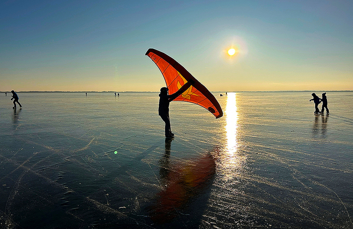 Человек занимается так называемым ледяным вингингом, наслаждаясь замерзшим озером Балатон недалеко от Вонярцвашедя в Венгрии.