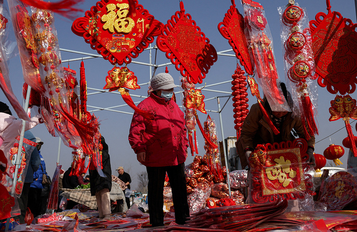 Торговля новогодними урашениями на рынке в Пекине.