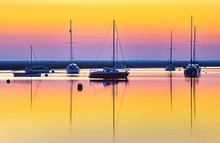 Рассвет в портовом городе Уэллс-Некст-зе-Си в графстве Норфолк на востоке Англии.