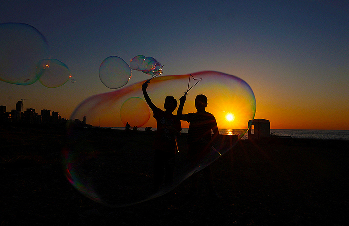 Дети играют с мыльными пузырями на набережной во время 10-дневного перемирия между Ливаном и Израилем в Бейруте.