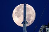 Лунная ракета-носитель Space Launch System (SLS) на фоне полной луны в Космическом центре Кеннеди на мысе Канаверал.
