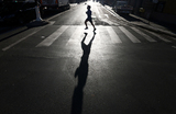 Одинокий бегун и его тень на пустынной улице в Париже, Франция.