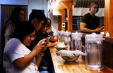 Посетители кафе фотографируют рамен с гигантским изоподом в ресторане Тайбэя, Тайвань.