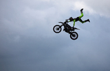 Гонщик из команды Extreme Bike Battle выполняет трюк в рамках Королевского шоу округа Чешир недалеко от Натсфорда, Великобритания.