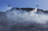 Вертолеты помогают тушить пожар в заливе Калк в Кейптауне, Южная Африка.