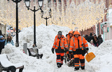 Сотрудники коммунальных служб во время уборки снега на Никольской улице в центре столицы.