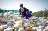 Ниханг (сикхский воин) отдыхает на баррикаде из мешков с песком во время протеста против низких цен на урожай у барьера Шамбху, границы между штатами Пенджаб и Харьяна, Индия.