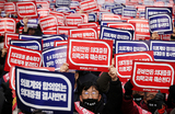 Южнокорейские врачи на массовом митинге против медицинской политики правительства в Сеуле, Южная Корея.