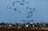 Посылки с гуманитарной помощью сбрасывают с военного самолета на фоне продолжающегося конфликта между Израилем и палестинской группировкой Хамас. Вид с границы Израиля с сектором Газа на юге Израиля.