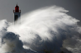 Волны разбиваются о маяк во время шторма «Нельсон» в Ле-Сабль-д'Олон, запад Франции.