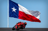 Итальянский мотогонщик Франческо Баньяя из команды Ducati Lenovo Team проезжает мимо флага Техаса во время тренировки. Гран-при Америки MotoGP, автодром Circuit of The Americas. 