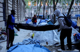 Мигранты, проживающие в стихийном палаточном лагере на площади Сен-Жерве возле мэрии Парижа, собирают свои вещи, поскольку жандармерия эвакуирует их временное пристанище.