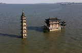 Вид на частично затопленный храм и пагоду на вершине острова Луосиндунь. Уровень воды в озере Поян приближается к историческому максимуму после сильных дождей в регионе в Лушане, провинция Цзянси, Китай.