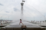 Девочка охлаждается в жаркую погоду в фонтане в парке 300-летия Санкт-Петербурга в Санкт-Петербурге, Россия.