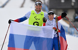 Российская лыжница Анастасия Багиян завоевала третье золото в личном зачете на Паралимпиаде в Италии. Лыжные гонки. Женщины. 20 км. Раздельный старт. На фото: Анастасия Багиян и спортсмен-ведущий Сергей Синякин.