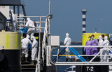 Специалисты поднимаются на борт круизного лайнера MV Hondius, пострадавшего от вспышки хантавируса, в порту Роттердама.